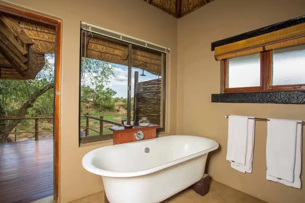 En-suite bathroom with bathtub, bathroom amenities and a river view.