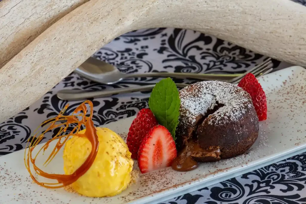 Stylish image of a chocolate volcano dessert with strawberries and sorbet.
