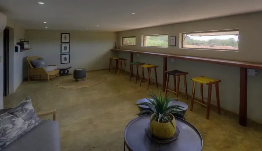 Interior layout of luxury hide with chairs, countertop, stools and views of the waterhole.