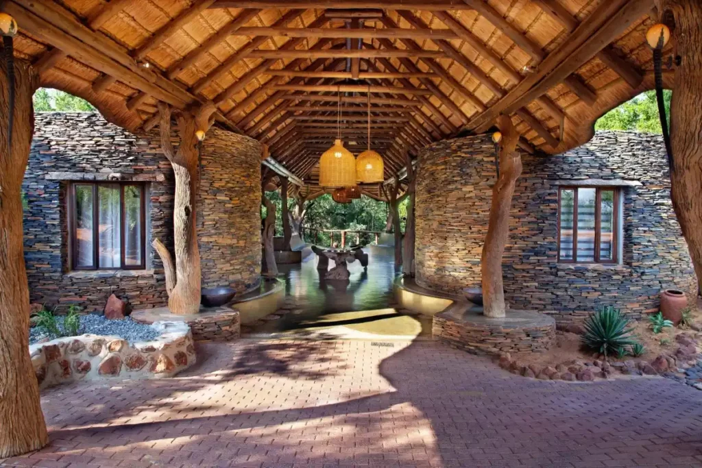 Rustic stone and timber entrance to the thatched main lodge.