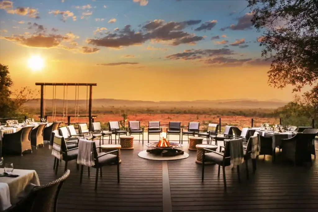 Sunset illuminating an elegant evening table setting and firepit, on the lodge deck.