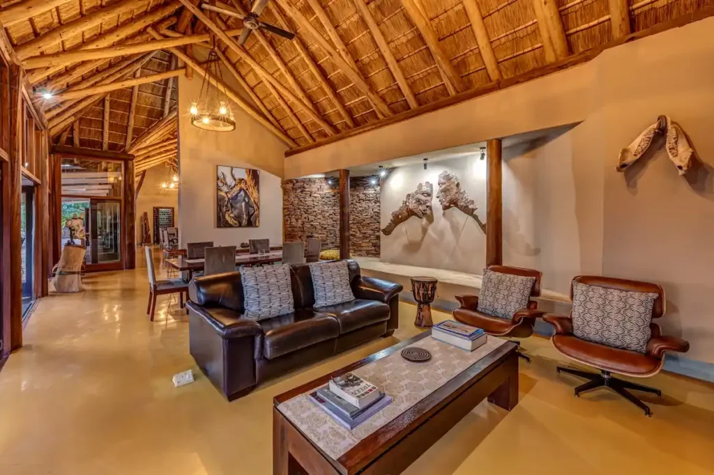 Rustic lodge lounge area showcasing local art pieces, coffee tables, comfortable sofas and chairs.