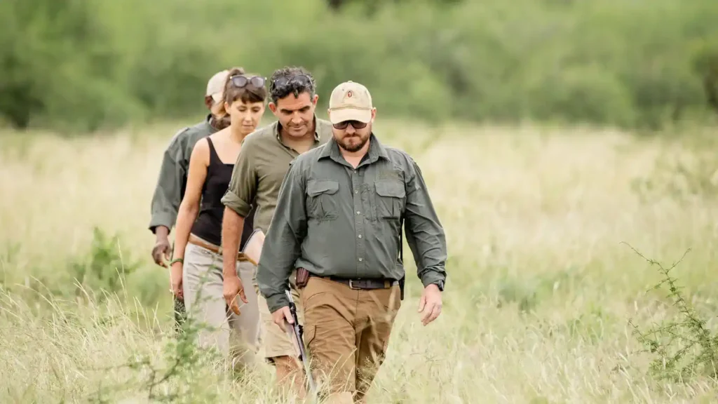 Armed guide leading tourists on a bush walking safari