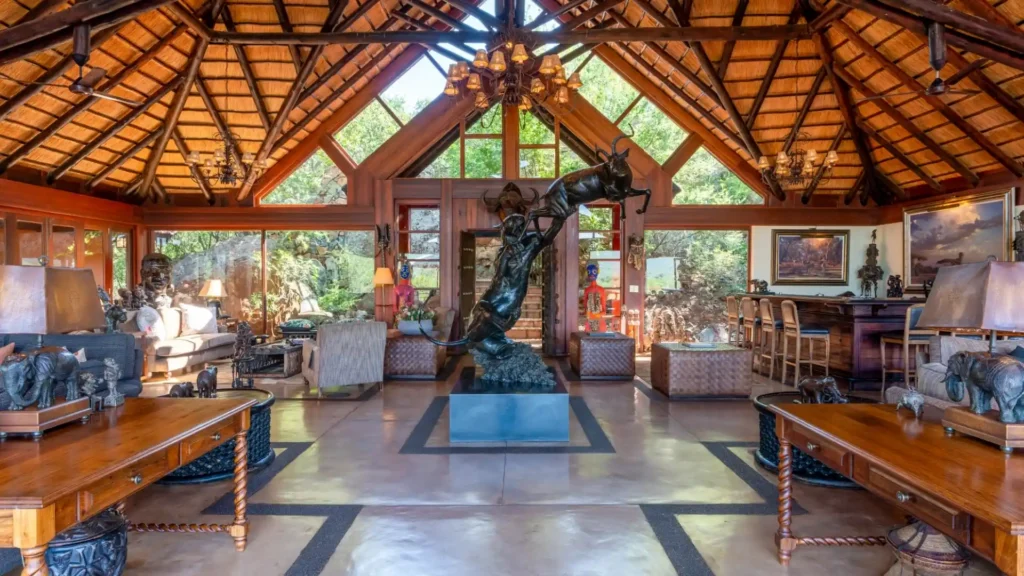 Luxury African safari lodge lounge with thatched roof and bronze sculpture
