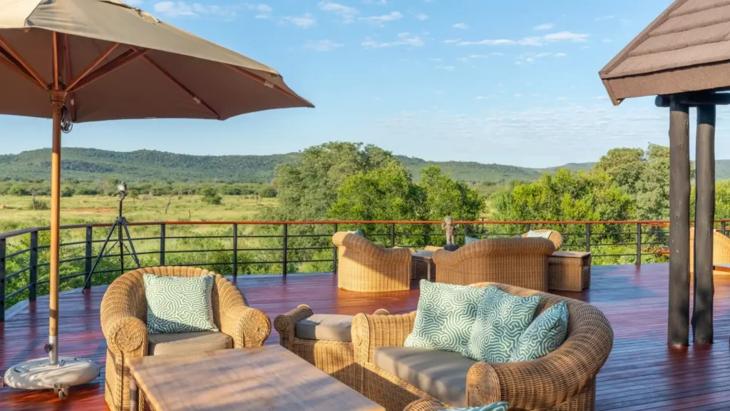 Safari lodge deck with wicker chairs overlooking African bushveld