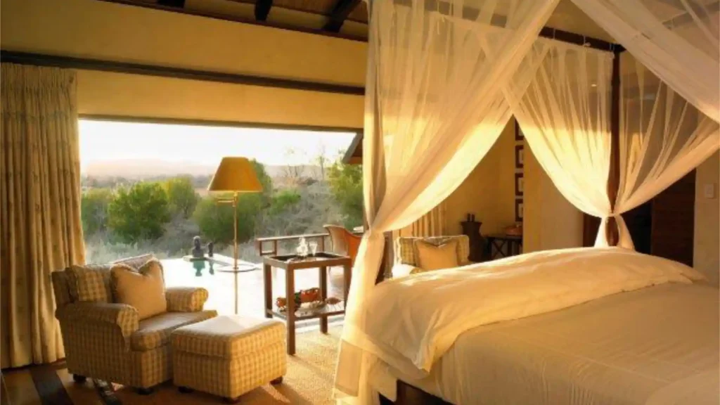 Luxury safari lodge bedroom with canopy bed and bush views